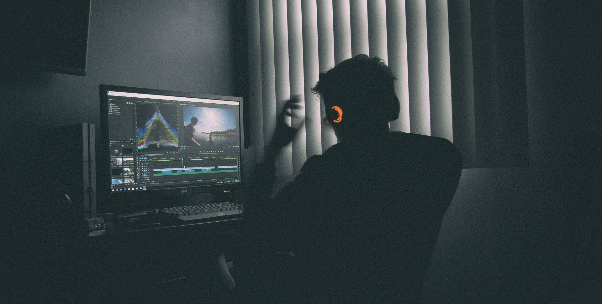 Video editor working at a workstation with editing software on screen